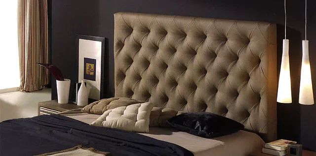 Una cama con cabecera capitoné en un dormitorio.