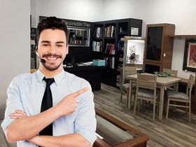 Un hombre que lleva unos auriculares señala algo en una sala de estar.