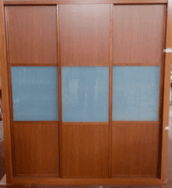 Un armario de madera con puertas corredizas de cristal azul.