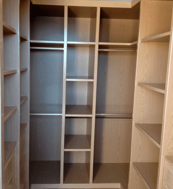 Un vestidor con muchos estantes y percheros.