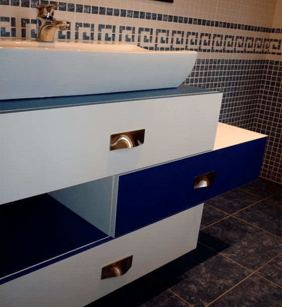 Un baño con cajones azules y blancos y un lavabo.