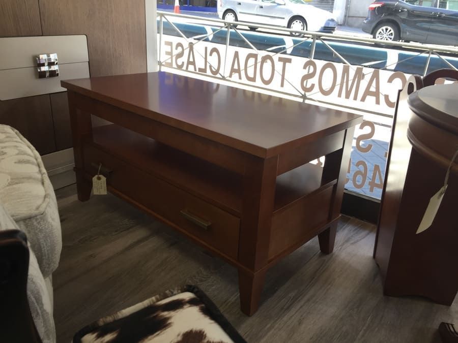 Una mesa de madera frente a una ventana que tiene escrito 