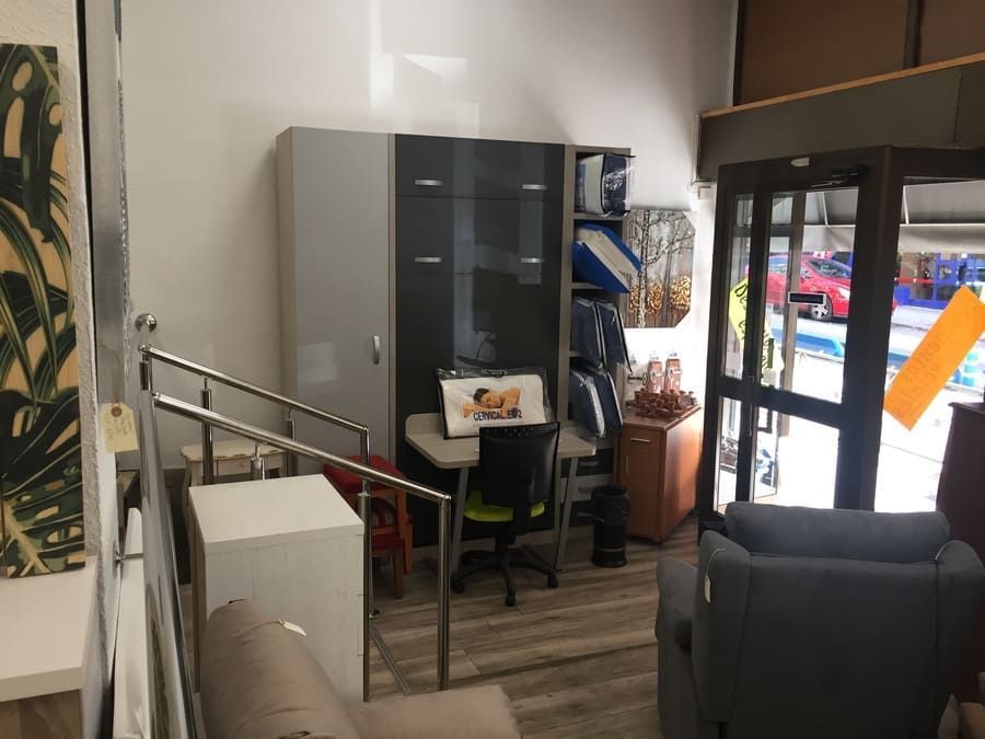 Una habitación llena de muebles y un escritorio con una computadora portátil encima.