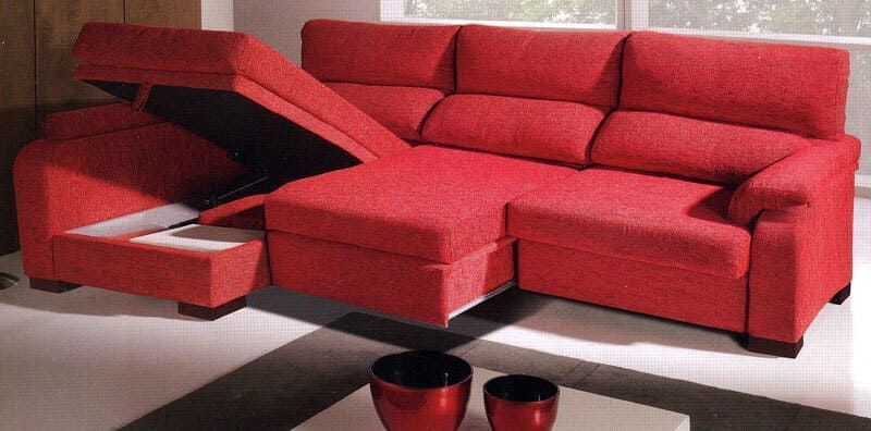 Un sofá seccional rojo con sus cajones de almacenamiento abiertos.