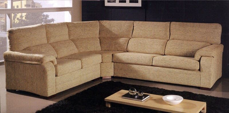 Una sala de estar con un sofá seccional y una mesa de café.