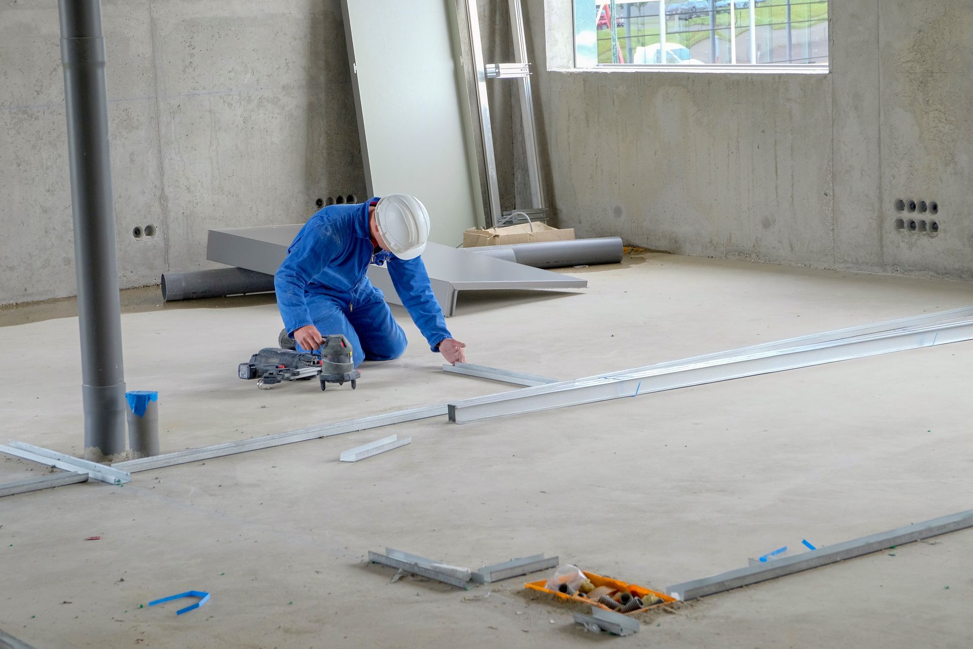 Un plaquiste travaillant au sol.