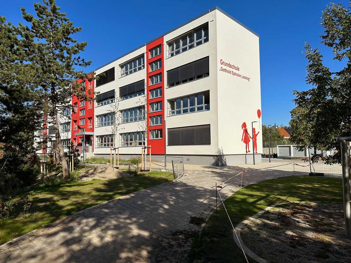 ein großes weißes und rotes Gebäude mit vielen Fenstern - Referenzen von BAUSON GmbH aus Gräfenhainichen