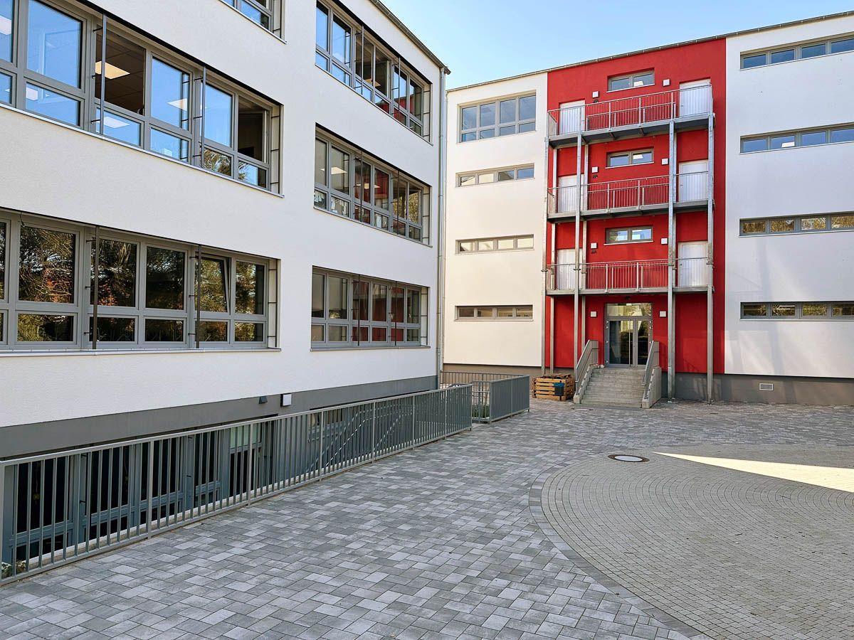 ein großes weißes und rotes Gebäude mit vielen Fenstern - Referenzen von BAUSON GmbH aus Gräfenhainichen