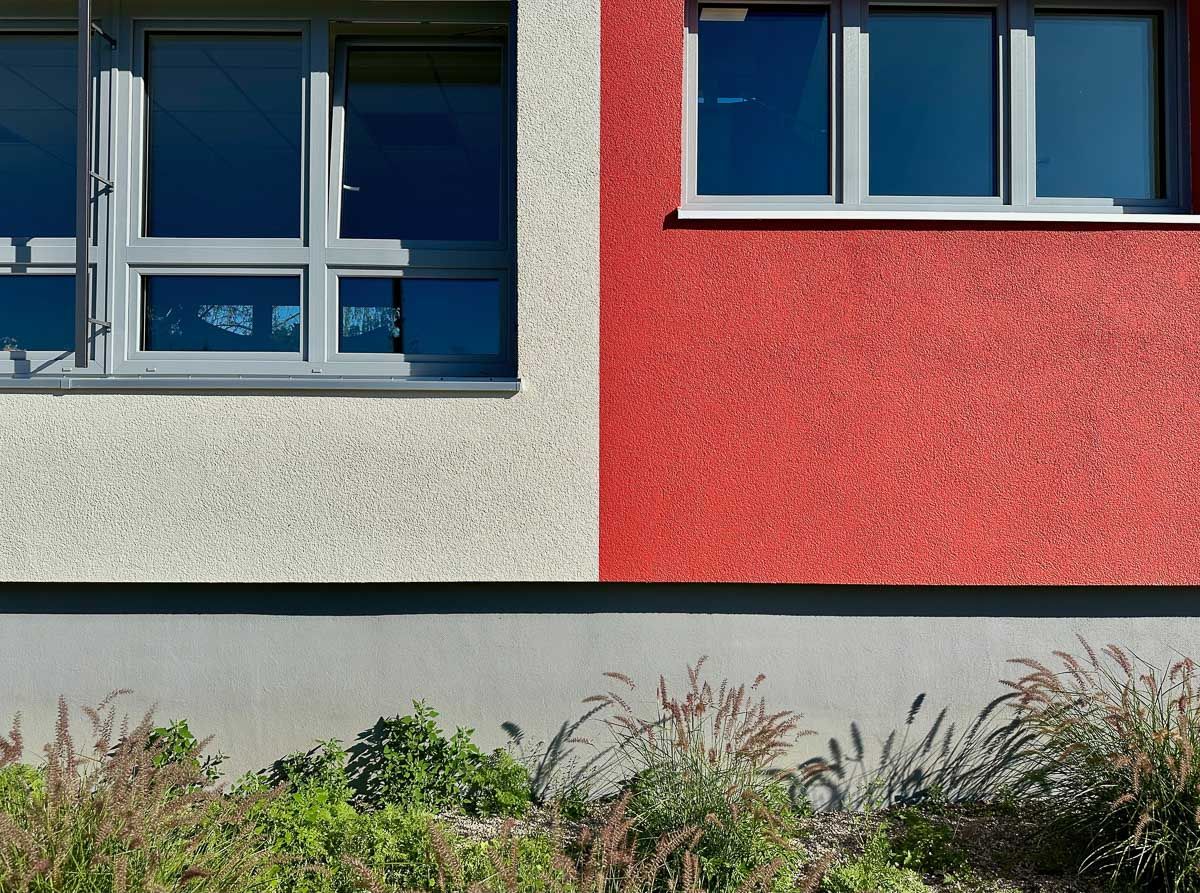 eine rote und weiße Fassade eines Gebäudes mit Fenstern - Referenzen von BAUSON GmbH aus Gräfenhainichen