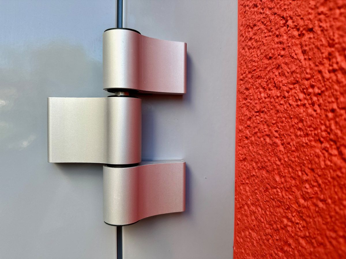 eine Nahaufnahme einer Türscharniere an einer roten Wand - Referenzen von BAUSON GmbH aus Gräfenhainichen