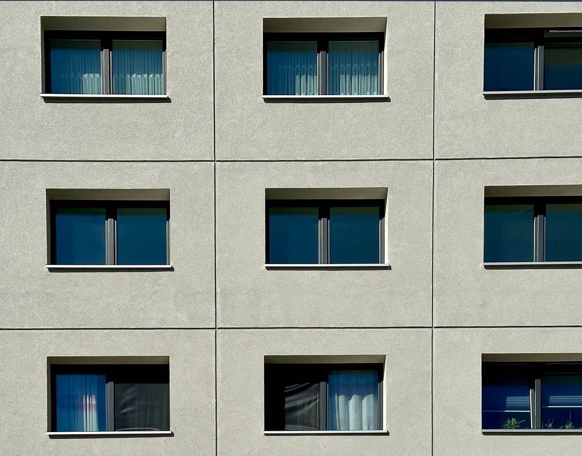 ein Gebäude mit vielen Fenstern und blauen Vorhängen - Referenzen von BAUSON GmbH aus Gräfenhainichen