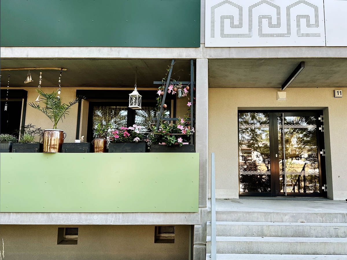 ein Gebäude mit einem grünen Balkon und einem weißen Schild darüber - Referenzen von BAUSON GmbH aus Gräfenhainichen