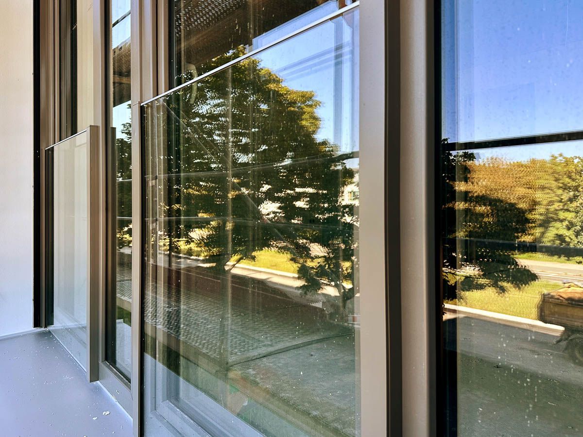 ein Gebäude mit vielen Fenstern und Bäumen spiegelt sich in den Fenstern - Referenzen von BAUSON GmbH aus Gräfenhainichen