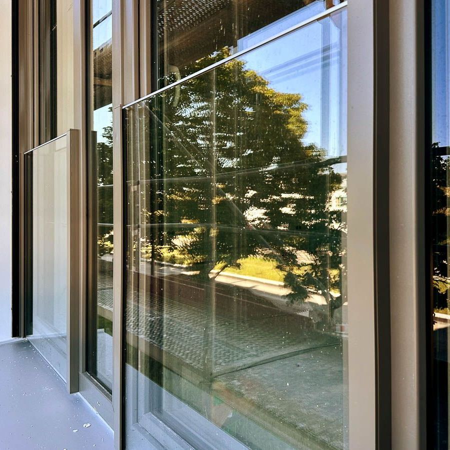 ein Gebäude mit vielen Fenstern und Bäumen spiegelt sich in den Fenstern - Referenzen von BAUSON GmbH aus Gräfenhainichen