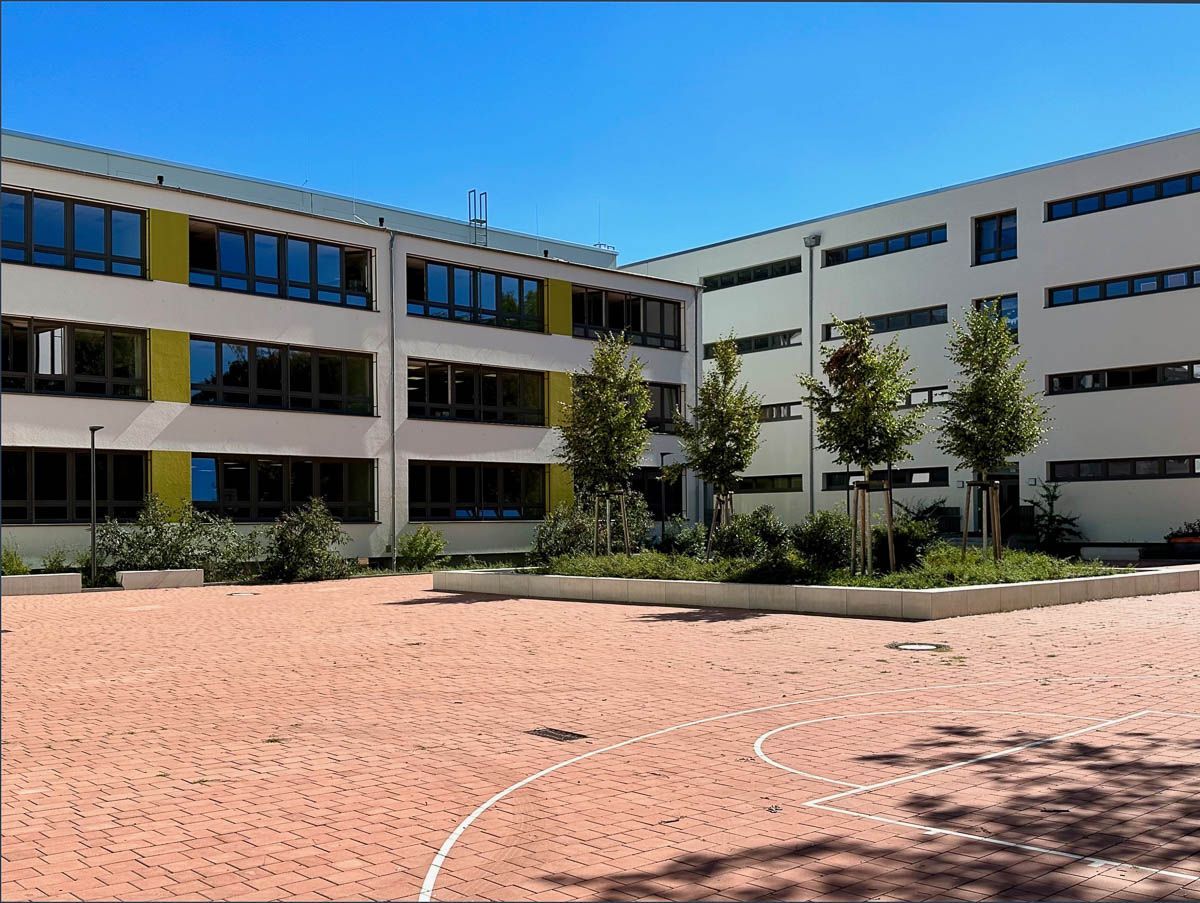 ein großes Gebäude mit vielen Fenstern und einem Spielplatz davor  - Referenzen von BAUSON GmbH aus Gräfenhainichen.