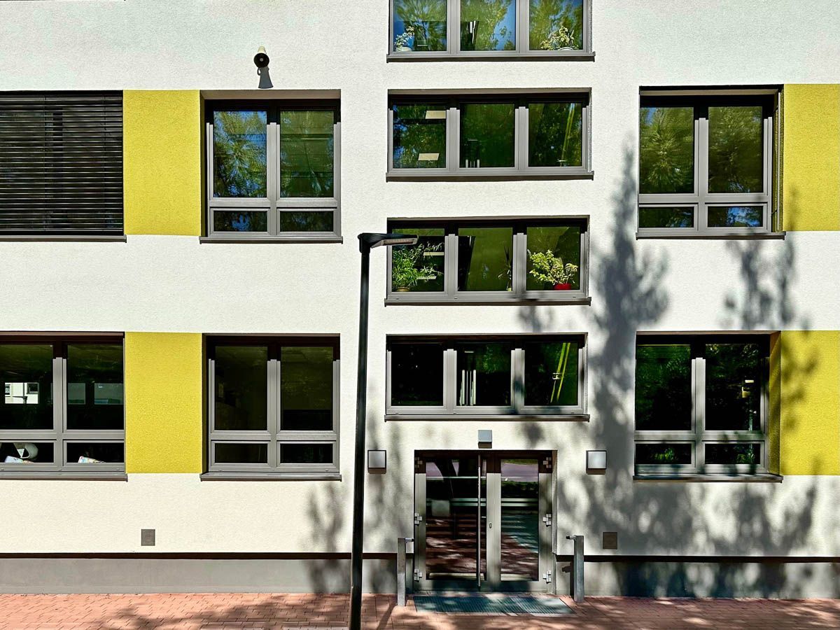 ein weißes und gelbes Gebäude mit vielen Fenstern - Referenzen von BAUSON GmbH aus Gräfenhainichen