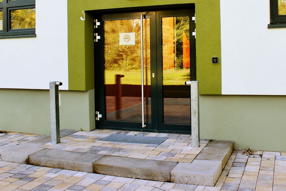 die Eingangstür eines Gebäudes mit einem Schild darauf - Referenzen von BAUSON GmbH aus Gräfenhainichen