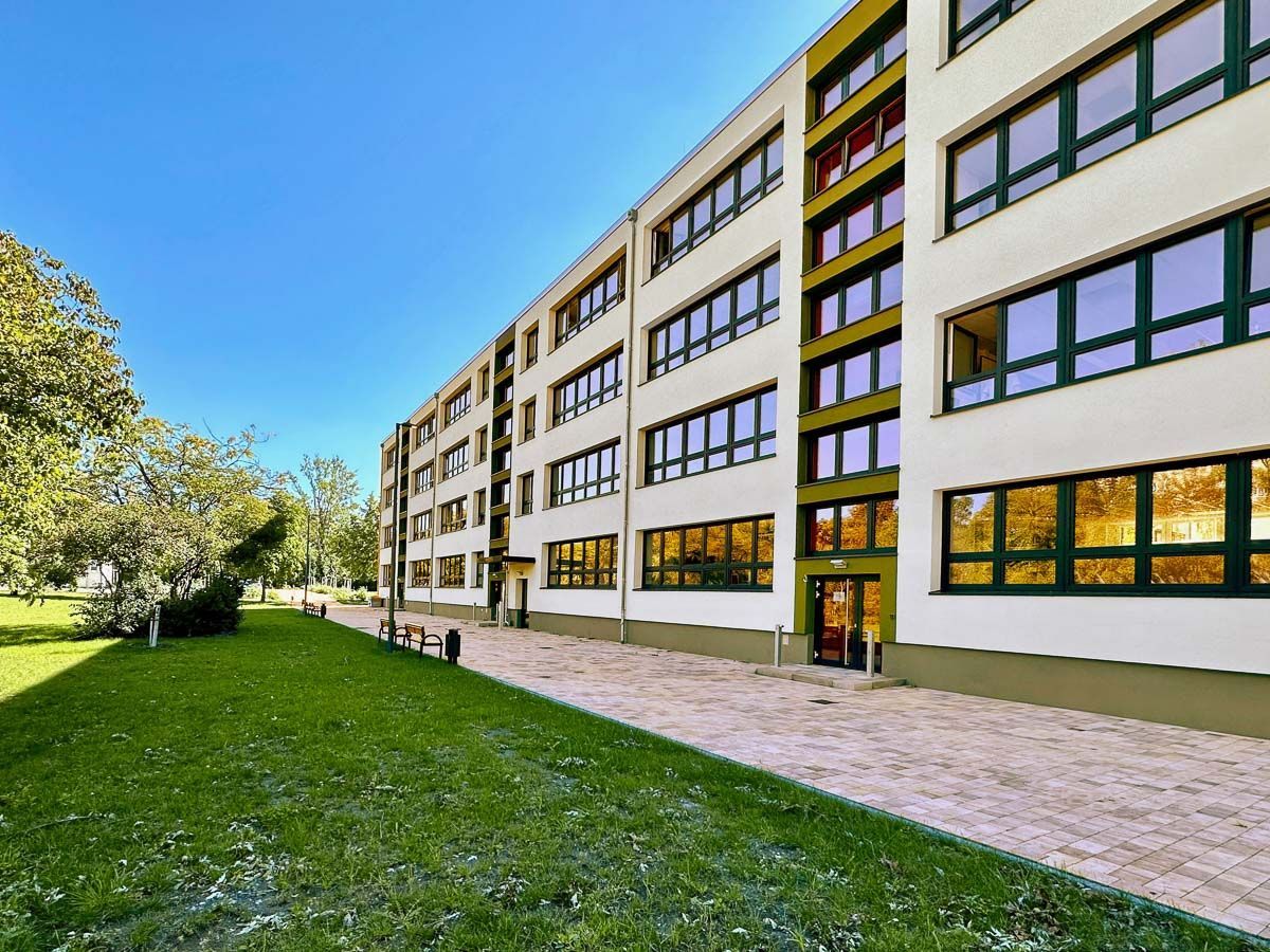 ein großes Gebäude mit vielen Fenstern und einem Park davor - Referenzen von BAUSON GmbH aus Gräfenhainichen