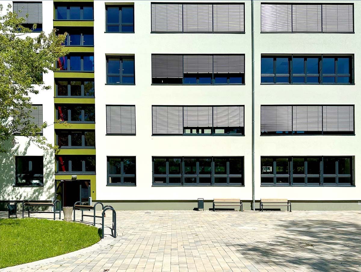 ein großes weißes Gebäude mit vielen Fenstern und Jalousien - Referenzen von BAUSON GmbH aus Gräfenhainichen