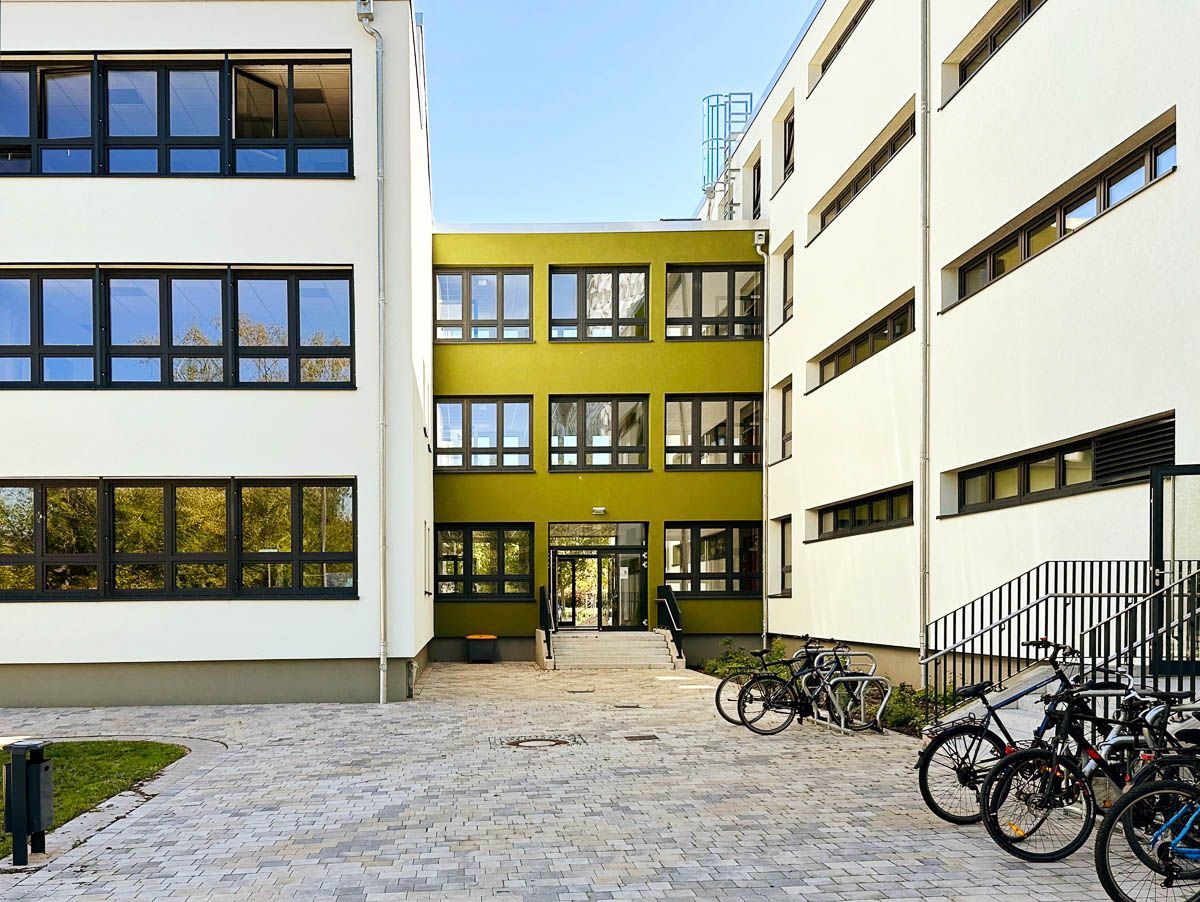 eine Gruppe von Fahrrädern , die vor einem großen Gebäude geparkt sind - Referenzen von BAUSON GmbH aus Gräfenhainichen