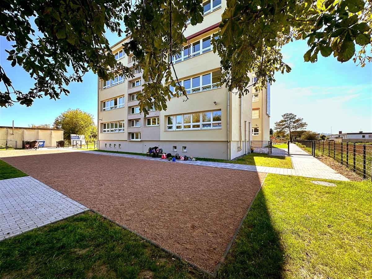 ein großes Gebäude mit vielen Fenstern und einem Parkplatz davor - Referenzen von BAUSON GmbH aus Gräfenhainichen