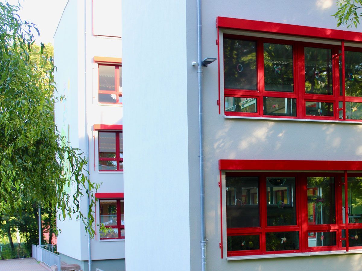 ein großes weißes Gebäude mit vielen roten Fenstern - Referenzen von BAUSON GmbH aus Gräfenhainichen