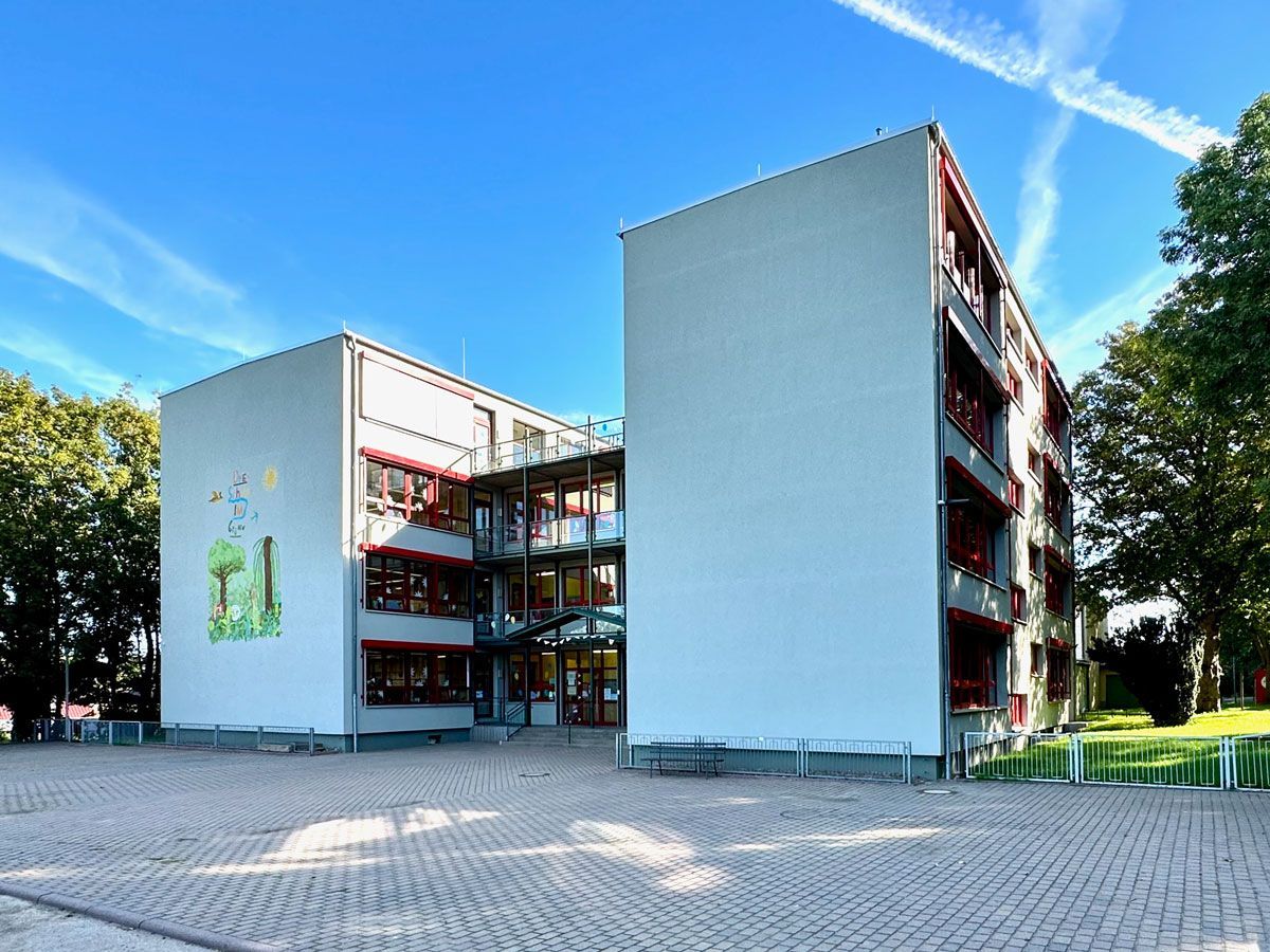 ein großes weißes Gebäude mit roten Fenstern und Balkonen - Referenzen von BAUSON GmbH aus Gräfenhainichen