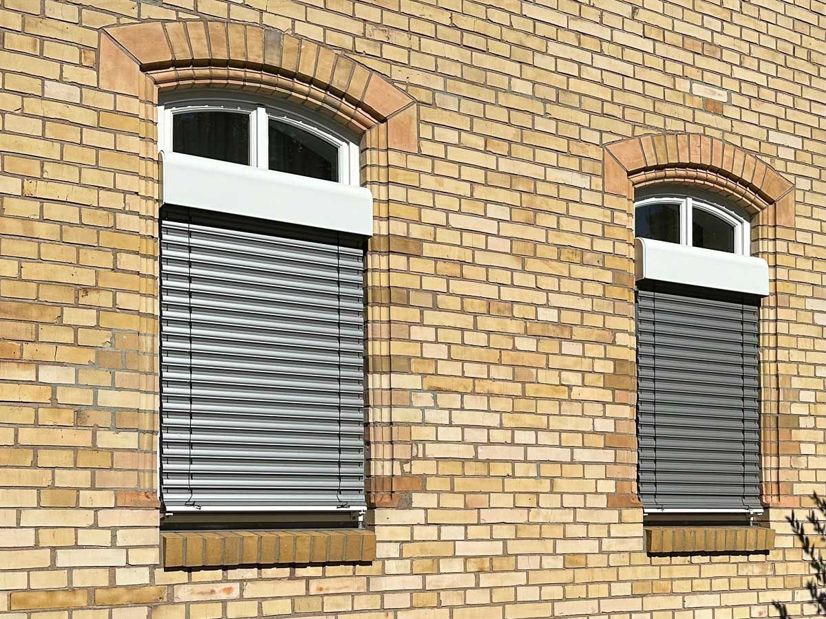 ein Backsteingebäude mit zwei Fenstern mit Rollläden - Referenzen von BAUSON GmbH aus Gräfenhainichen