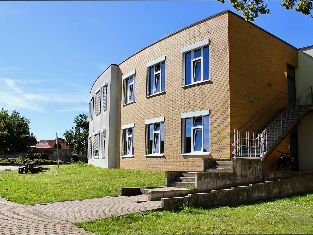 ein großes Backsteingebäude mit vielen Fenstern und einer Treppe - Referenzen von BAUSON GmbH aus Gräfenhainichen