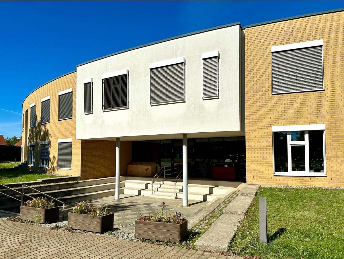 ein großes Backsteingebäude mit vielen Fenstern und einer Treppe - Referenzen von BAUSON GmbH aus Gräfenhainichen