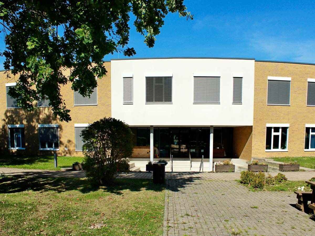 ein großes Backsteingebäude mit einem weißen Dach und vielen Fenstern - Referenzen von BAUSON GmbH aus Gräfenhainichen