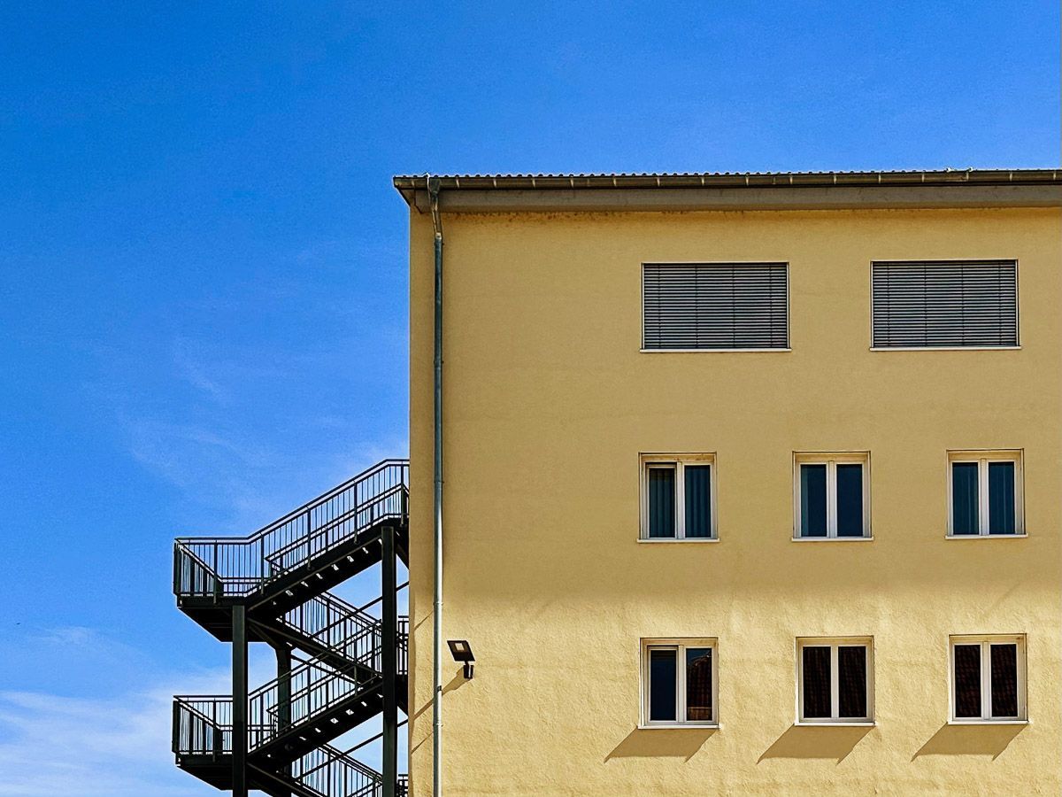 ein gelbes Gebäude mit einer Feuertreppe an der Seite - Referenzen von BAUSON GmbH aus Gräfenhainichen