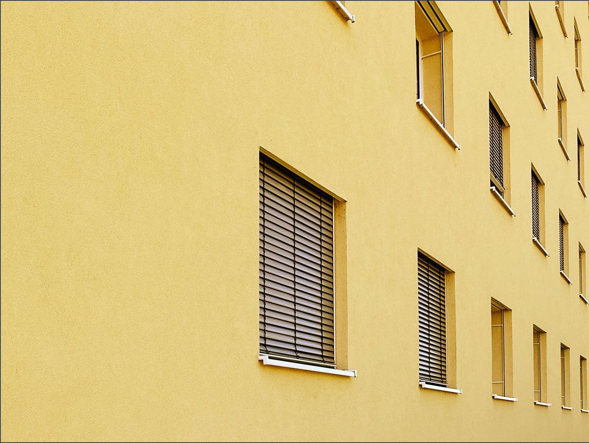 ein gelbes Gebäude mit vielen Fenstern und Jalousien - Referenzen von BAUSON GmbH aus Gräfenhainichen