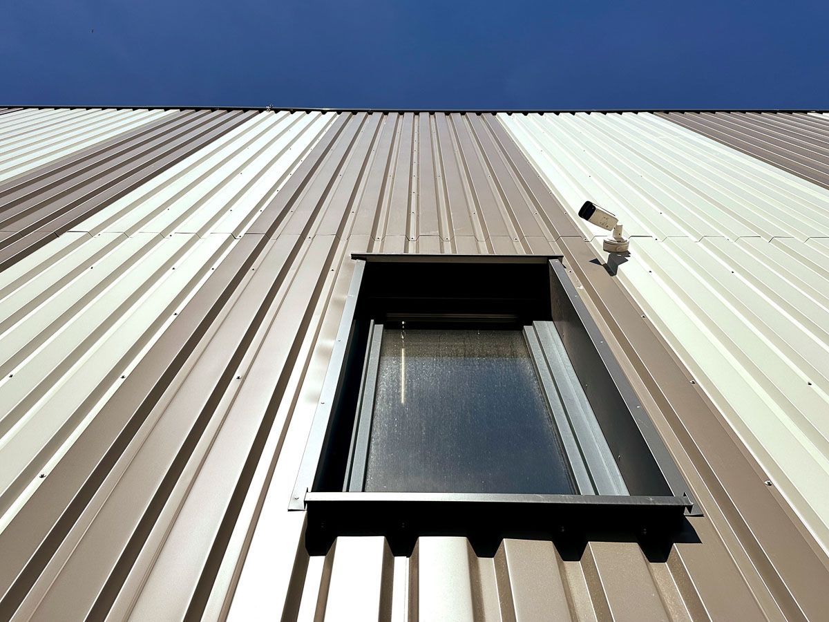 ein braun-weißes Gebäude mit einem Fenster auf dem Dach - Referenzen von BAUSON GmbH aus Gräfenhainichen