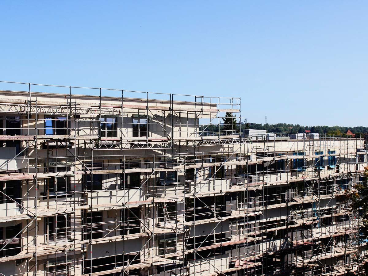 ein großes Gebäude , das mit Gerüst gebaut wird - Referenzen von BAUSON GmbH aus Gräfenhainichen