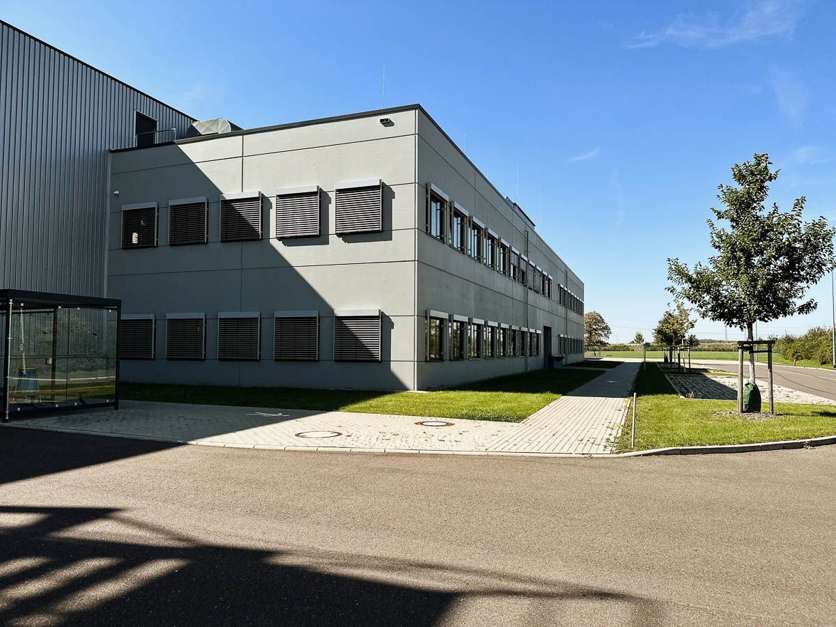 ein großes Gebäude mit vielen Fenstern und Bäumen davor - Referenzen von BAUSON GmbH aus Gräfenhainichen