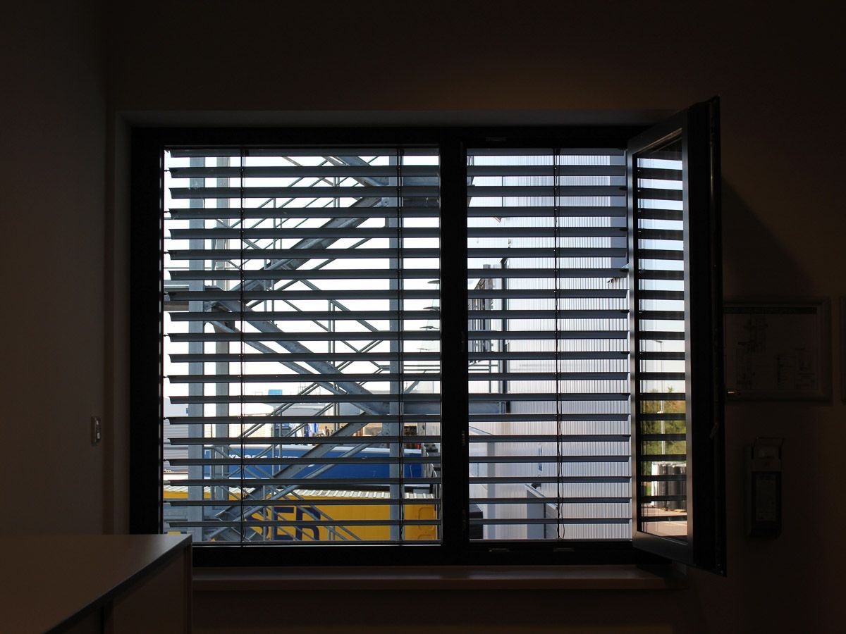 ein Fenster mit Jalousien und einer Treppe im Hintergrund - Referenzen von BAUSON GmbH aus Gräfenhainichen