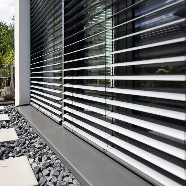 eine Nahaufnahme eines Fensters mit Jalousien - Sonnenschutz von Warema - eingebaut von BAUSON GmbH aus Gräfenhainichen