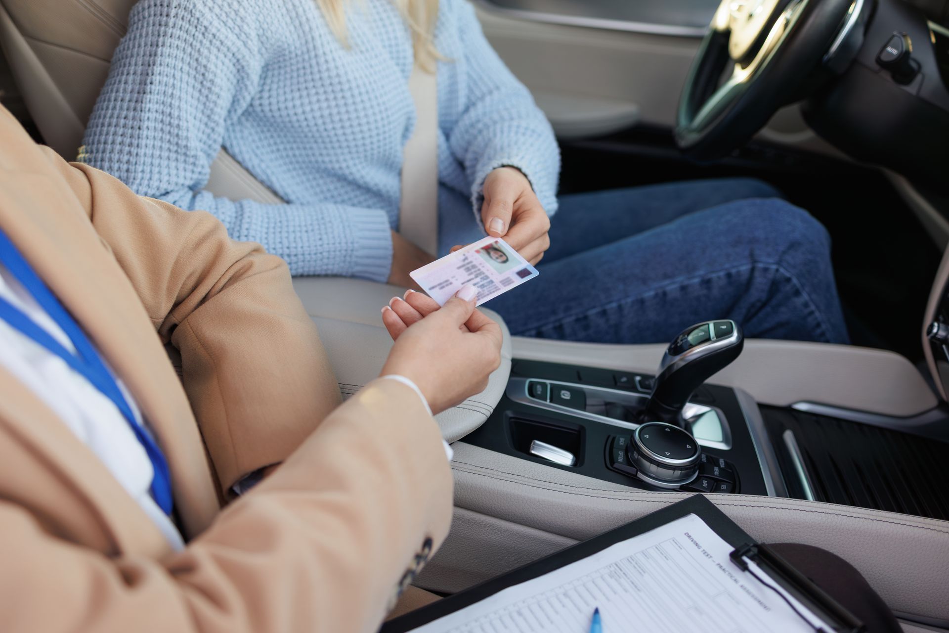 Deux personnes dans une voiture échangent une carte près de la console centrale.