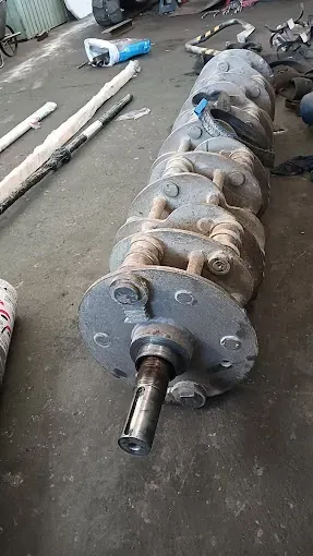 Un gran objeto metálico se encuentra en el suelo de un garaje.