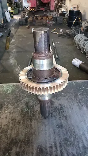 Un engranaje está encima de una mesa en un garaje.