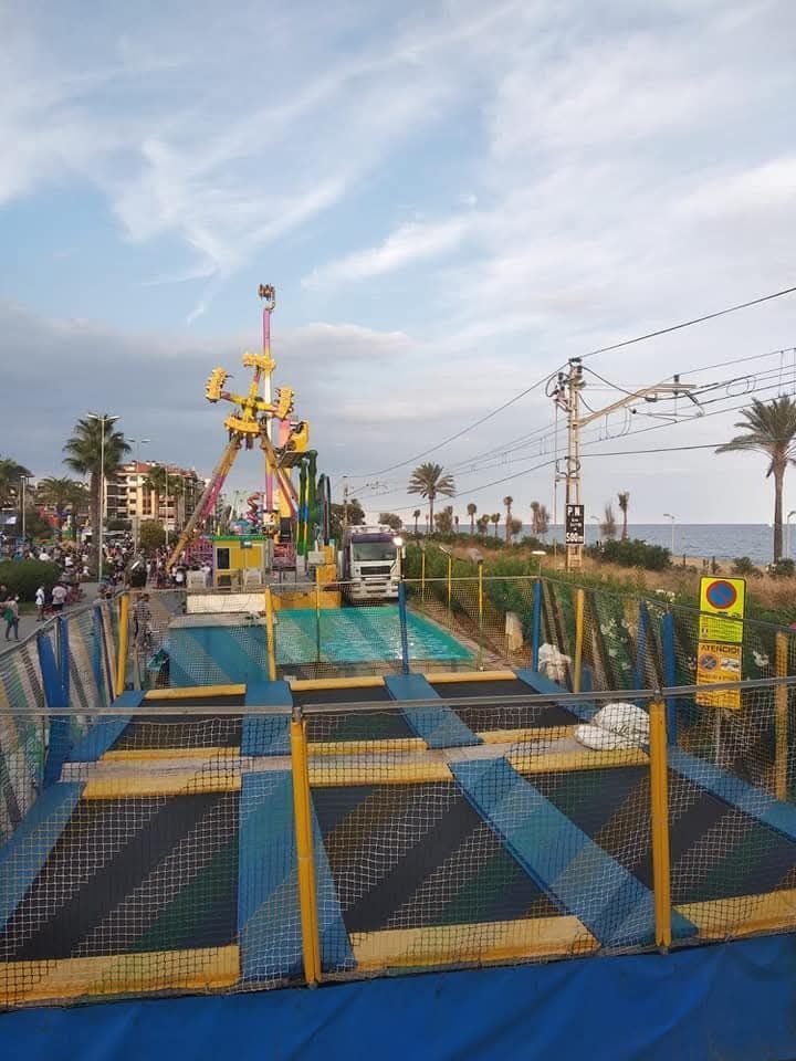 Parque ferial con atracciones, trampolines, sky y playa.