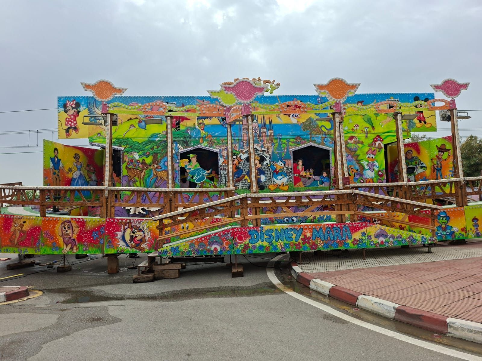 Colorido paseo de carnaval con figuras pintadas bajo un cielo nublado.