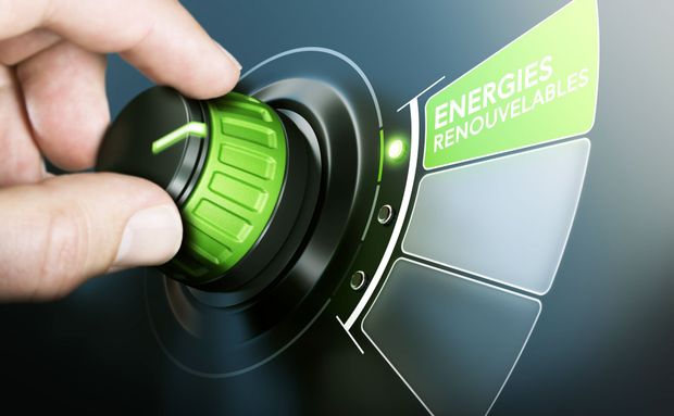 Une main tournant un bouton vert sur un cran nommé énergies renouvelables