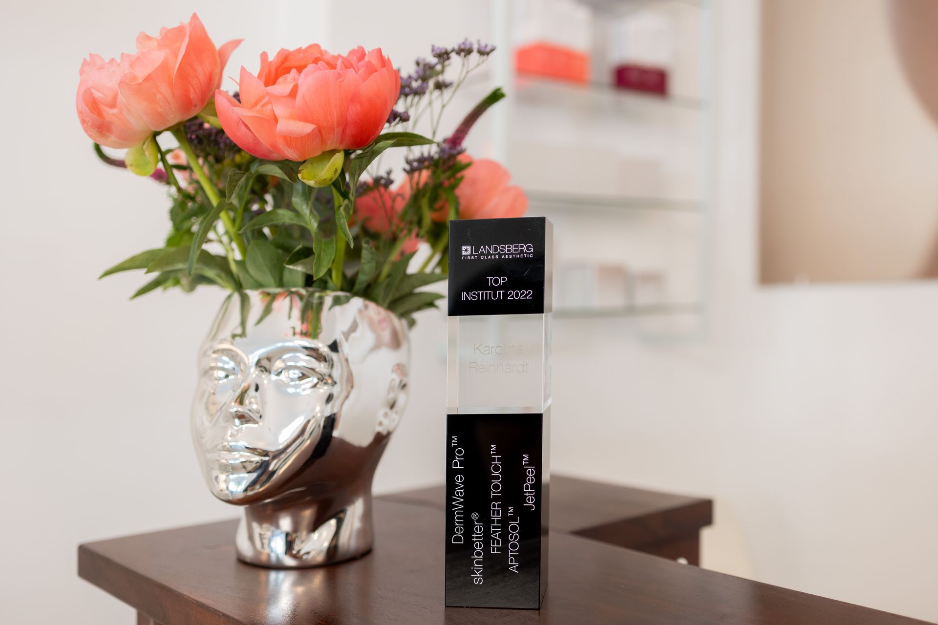 Auf einem Tisch steht eine Vase mit Blumen neben einer Kiste.