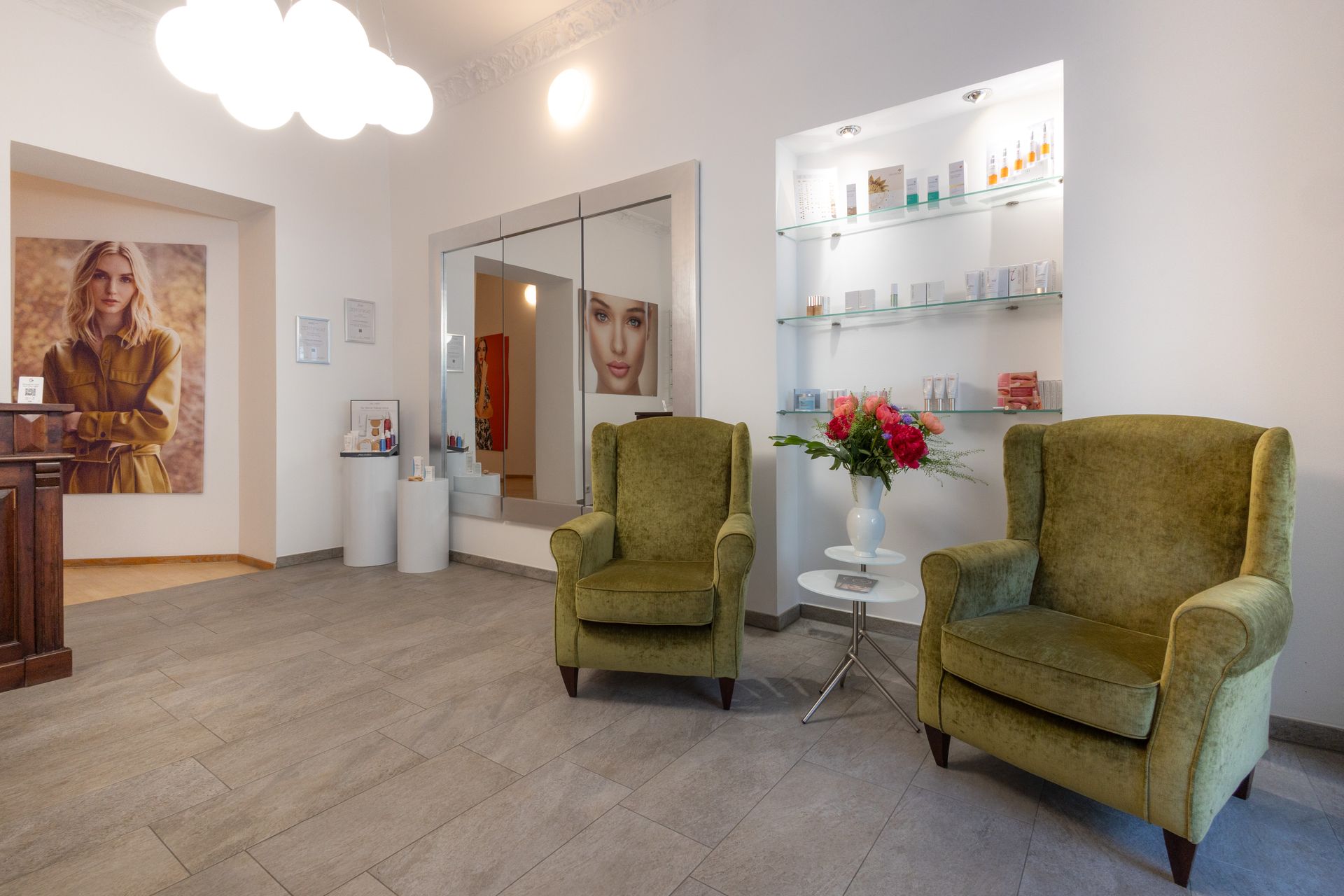 Ein Wartezimmer mit zwei grünen Stühlen und einem Tisch.