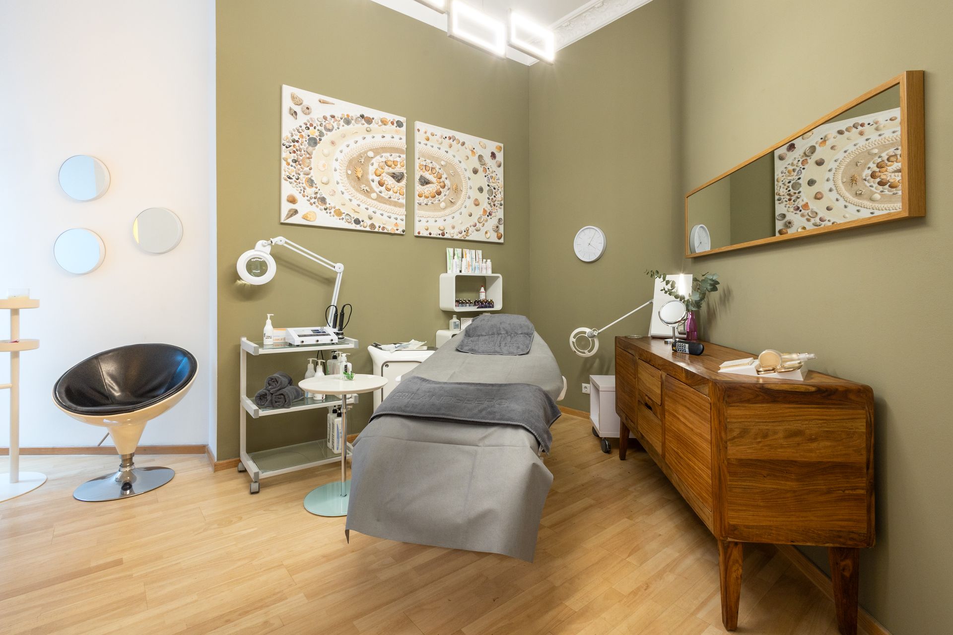 Ein Zimmer mit Bett, Stuhl, Kommode und Spiegel.