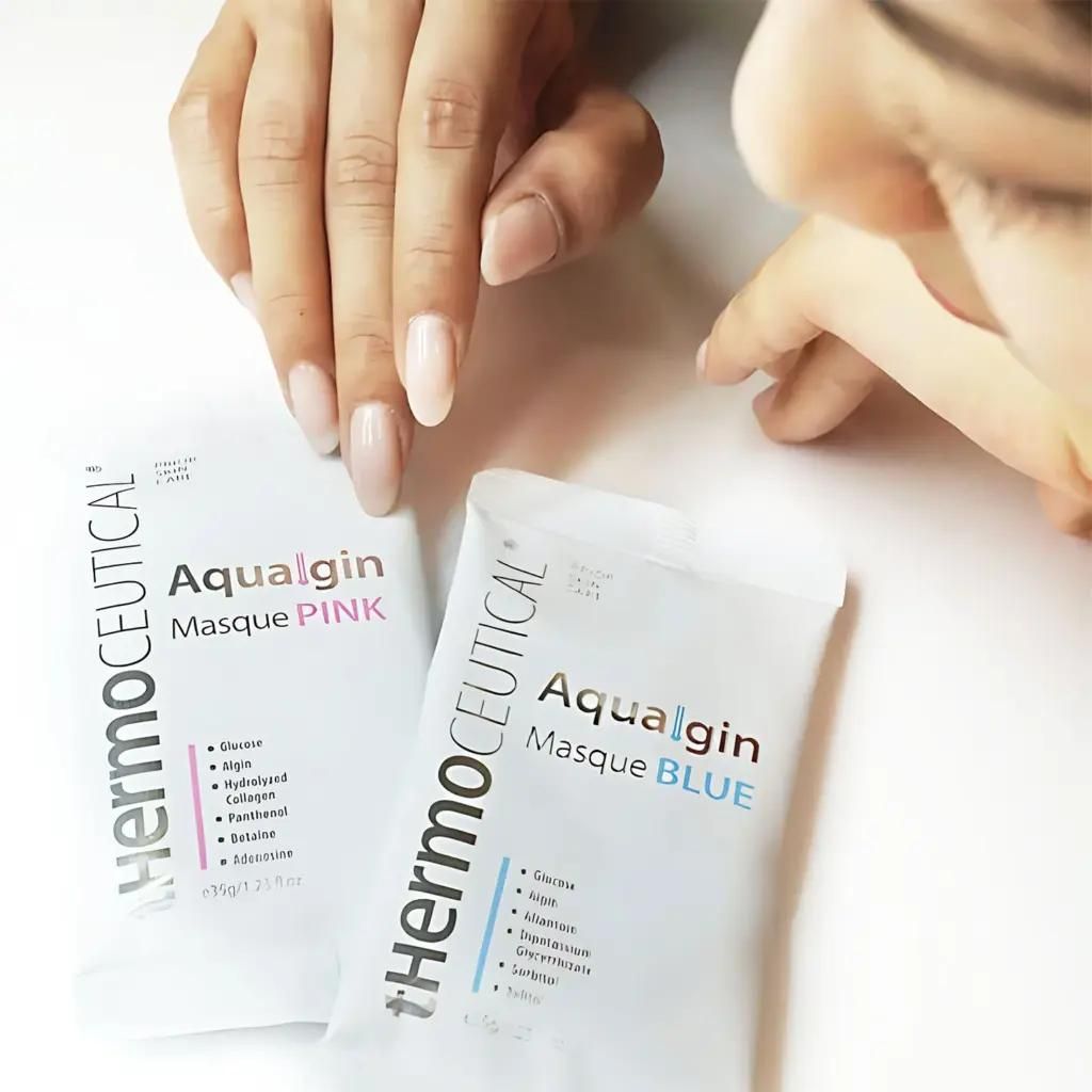 Eine Frau hält eine Packung Aquagin Masque Pink und Aquagin Masque Blue in der Hand