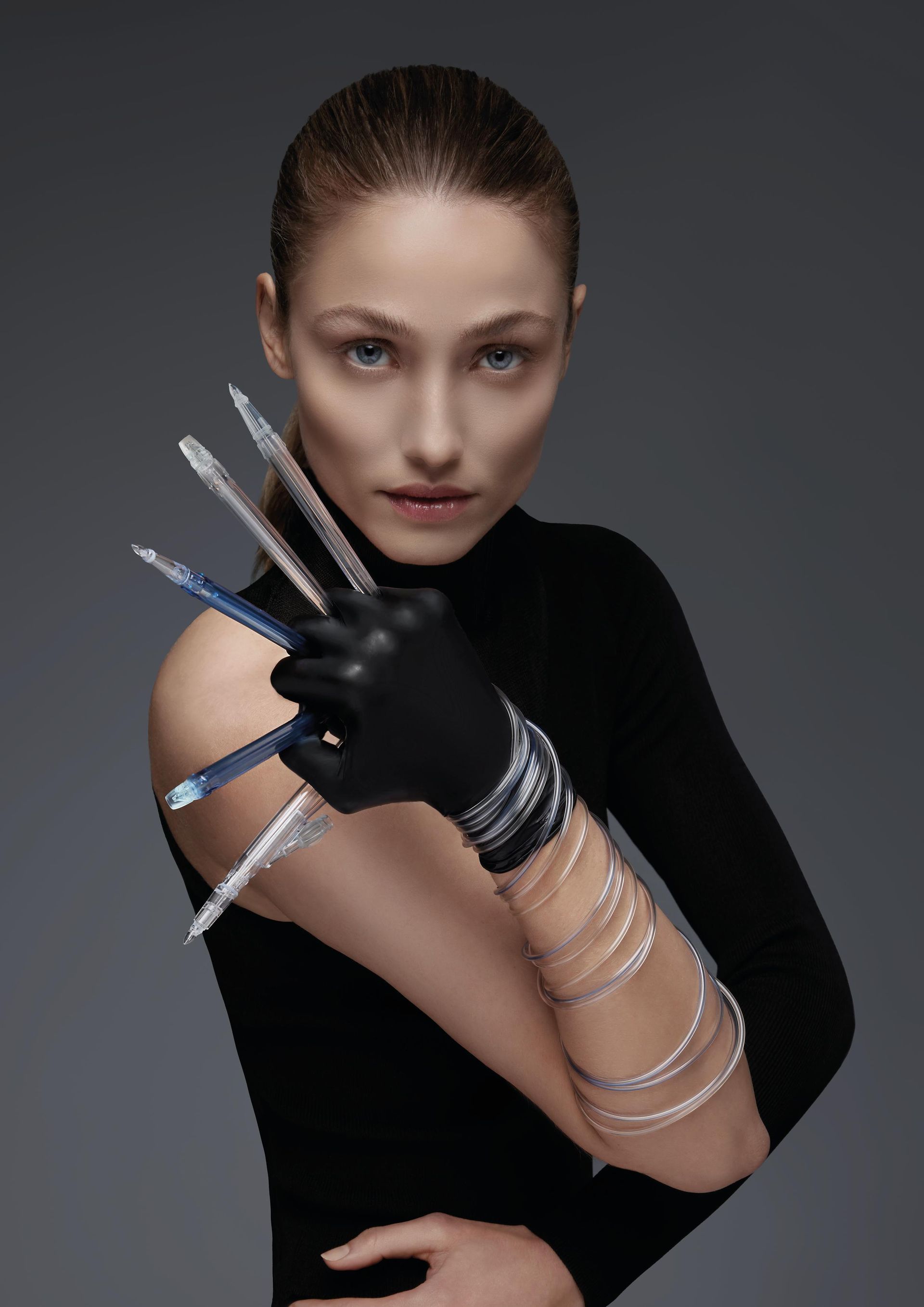 Eine Frau mit einem schwarzen Handschuh hält einen Haufen Stifte