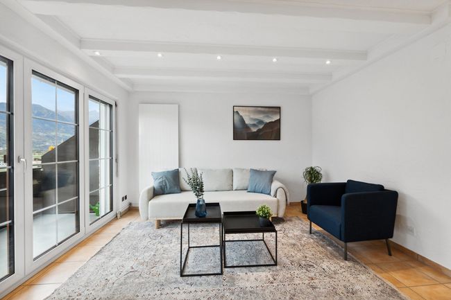 A living room with a couch , chair , and table.